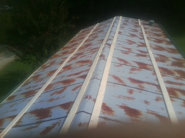 Rusted metal roof panels with new wood purlins before replacement — Storm Damage Roof Repair in Wells Bridge by Roofing Brothers